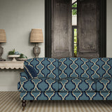 Sofa upholstered in a printed linen fabric in blue, black, and off white featuring a mirrored ribbon pattern.