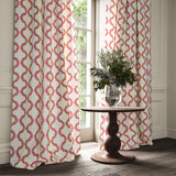 Curtains made from a printed linen fabric in pink, yellow, and off white featuring a mirrored ribbon pattern.