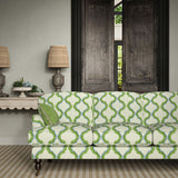 Sofa upholstered in a printed linen fabric in blue, green, and off white featuring a mirrored ribbon pattern.