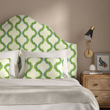 Headboard upholstered in a printed linen fabric in blue, green, and off white featuring a mirrored ribbon pattern.