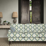 Sofa upholstered in a printed linen fabric in blue, green, and off white featuring a mirrored ribbon pattern.