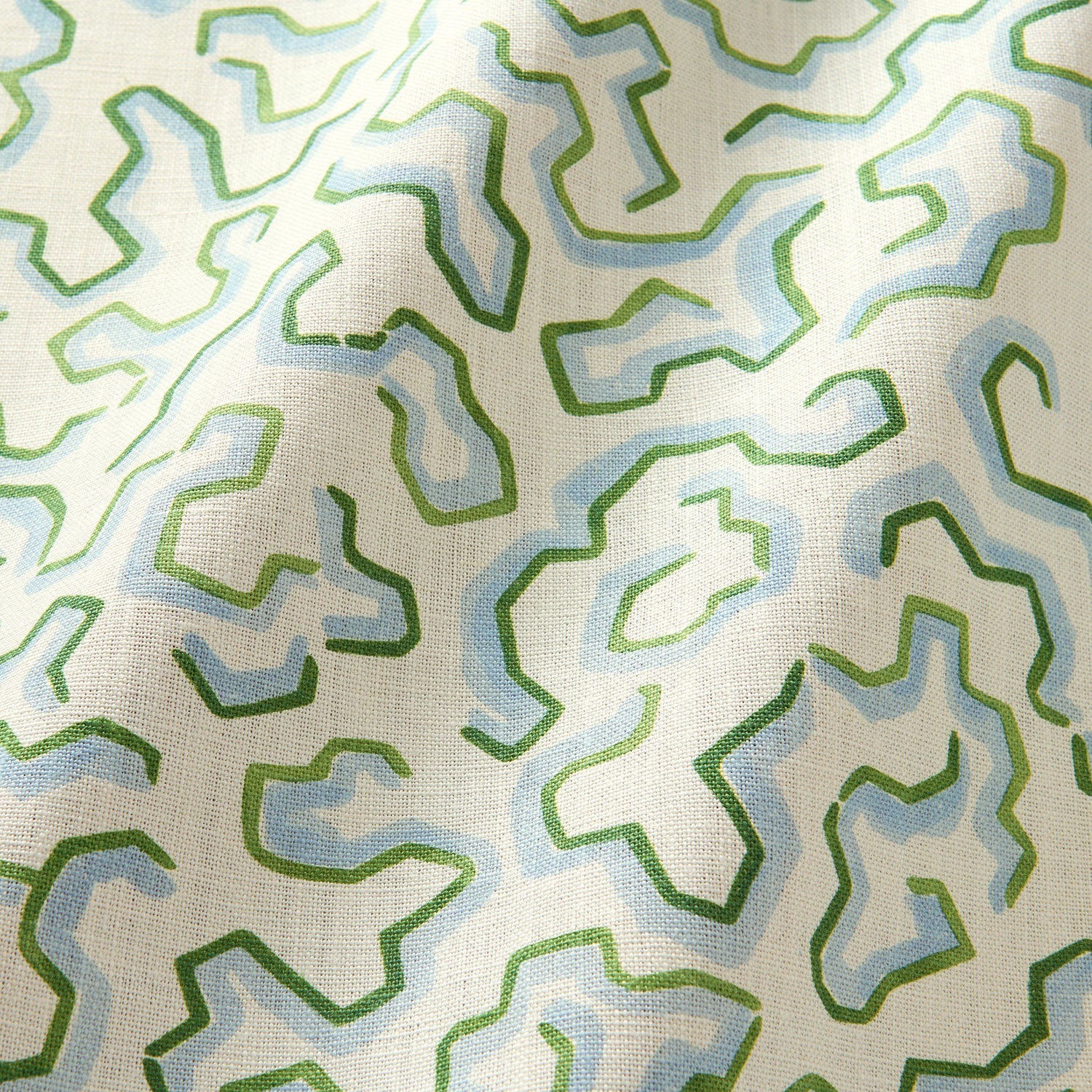 A printed linen fabric sample in blue, green, and off white featuring a feel of a classic animal print.