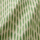 A printed linen fabric sample in green and off white featuring a Japanese print.