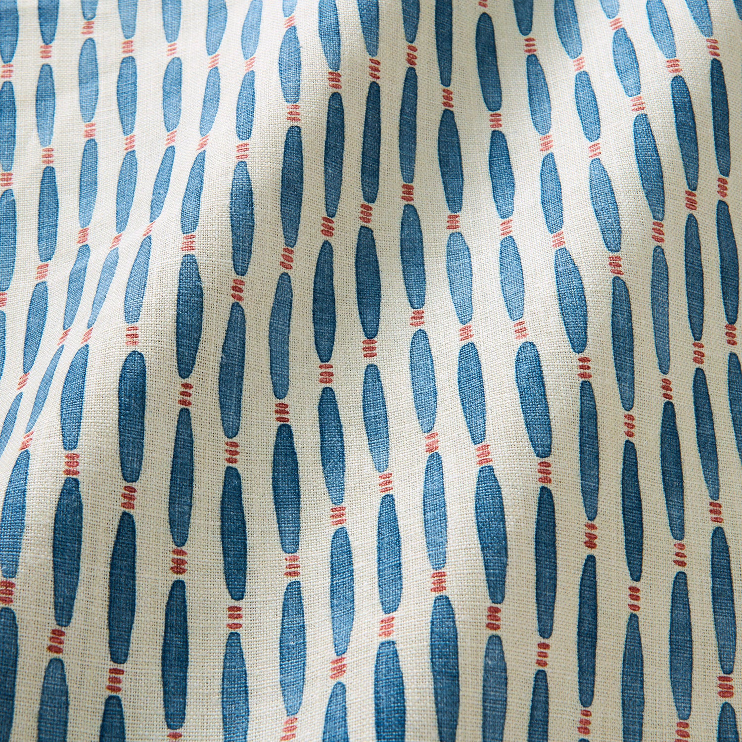 A printed linen fabric sample in blue, orange, and off white featuring a Japanese print.