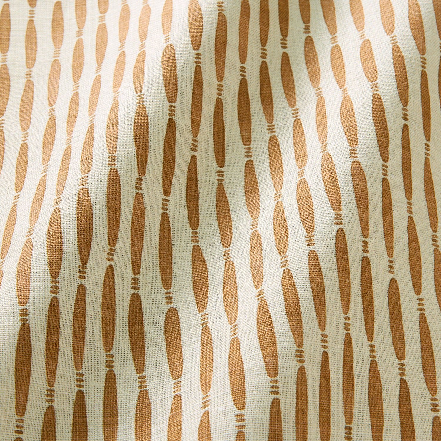 A printed linen fabric sample in orange and off white featuring a Japanese print.