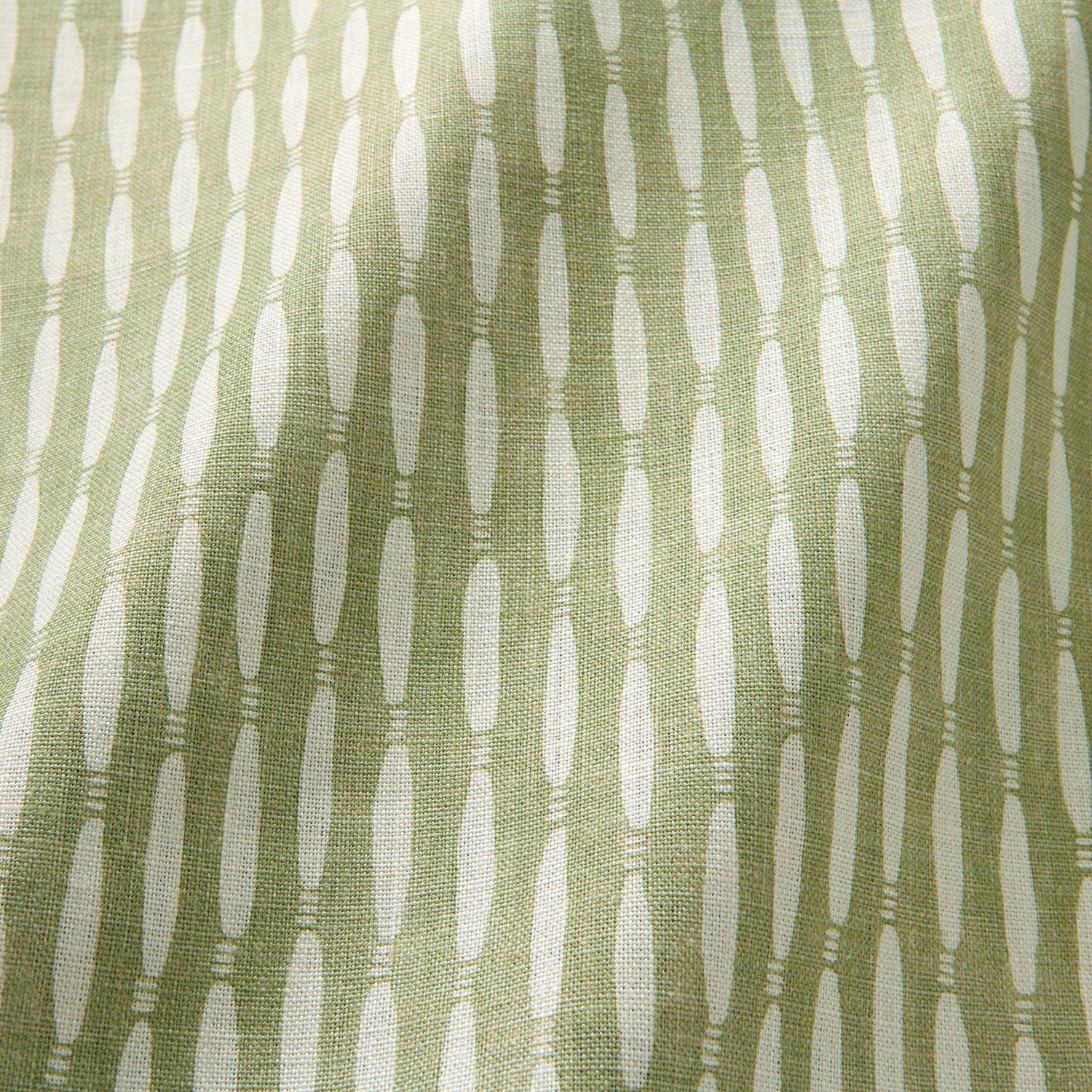 A printed linen fabric sample in green and off white featuring a Japanese print.