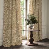 Curtains made from a printed linen fabric in brown, orange, and off white featuring a feel of a classic animal print.