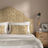 Headboard upholstered in a printed linen fabric in brown, orange, and off white featuring a feel of a classic animal print.
