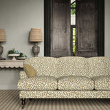 Sofa upholstered in a printed linen fabric in brown, beige, and off white featuring a feel of a classic animal print.