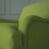 Close up of armchair in Loxley Apple by Linwood – durable, Italian-woven natural fibre fabric in soft green.