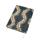A blue, brown and cream linen notebook with a classic trellis pattern.