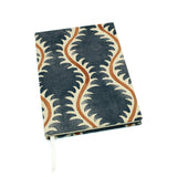 A blue, brown and cream linen notebook with a classic trellis pattern.