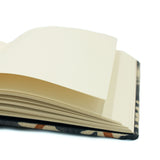 A blue, brown and cream linen notebook with a classic trellis pattern.