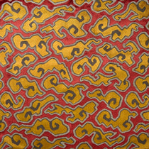 A woven velvet fabric sample in red, yellow and brown featuring a stylised cloud pattern.