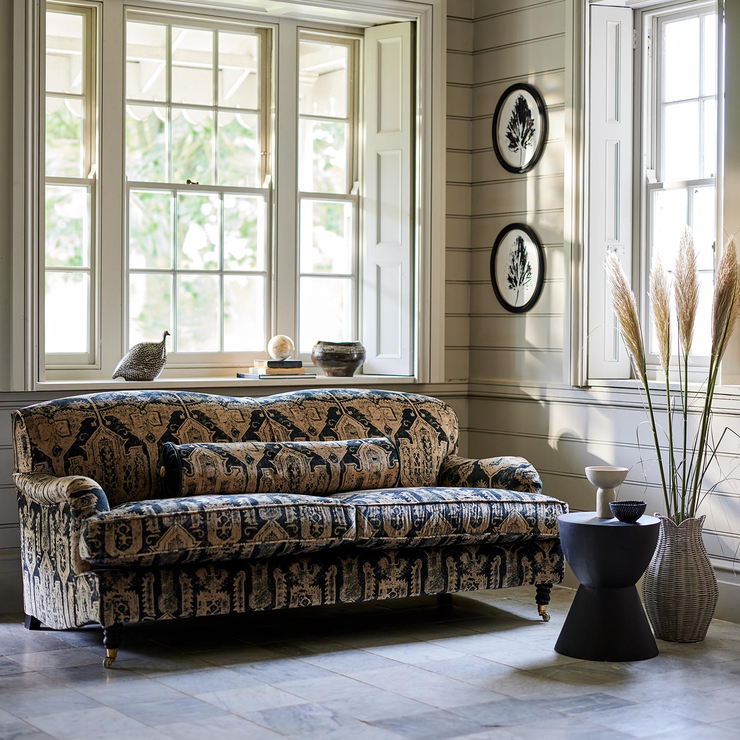 Sofa upholstered in a printed velvet fabric in brown and black featuring a Turkish kilim pattern.