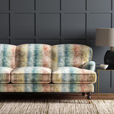 A sofa in a multicoloured printed velvet with pastel stripes.