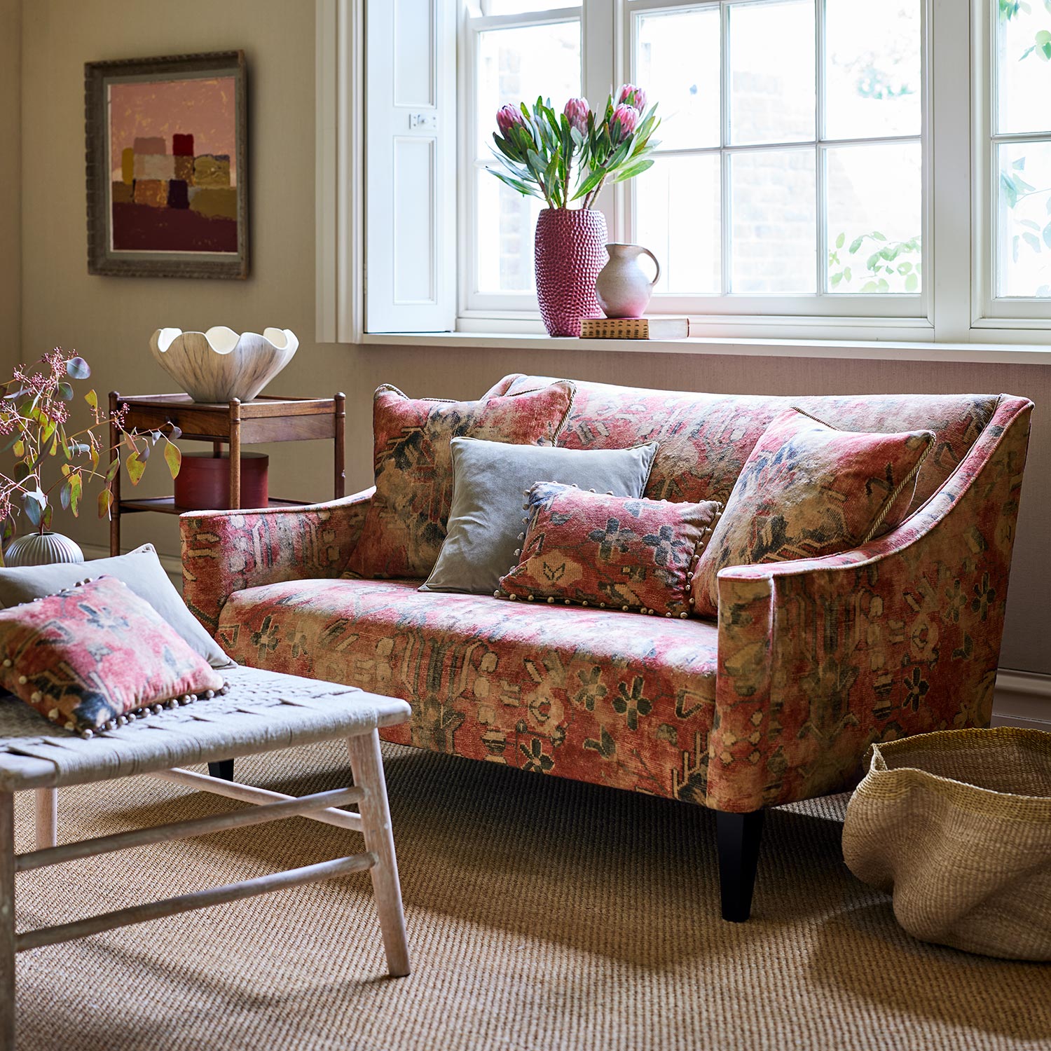 Sofa upholstered in a printed velvet fabric in red with the feel of a vintage rug.