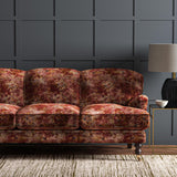 Sofa upholstered in a printed velvet fabric in red and brown featuring a classic distressed pattern.