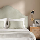 Headboard upholstered in a plain luxurious woven fabric in cream.