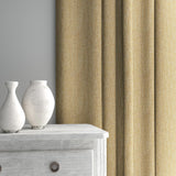 Curtain made from a plain luxurious woven fabric in yellow.