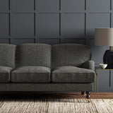 Sofa upholstered in a plain luxurious woven fabric in grey.