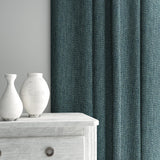 Curtain made from a plain luxurious woven fabric in blue.