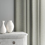 Curtain made from a plain luxurious woven fabric in grey.