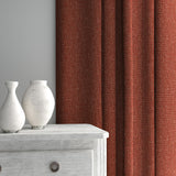 Curtain made from a plain luxurious woven fabric in red.