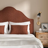 Headboard upholstered in a plain luxurious woven fabric in red.