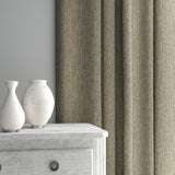 Curtain made from a plain luxurious woven fabric in brown.