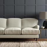 Sofa upholstered in a plain luxurious woven fabric in cream.