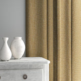 Curtain made from a plain luxurious woven fabric in yellow.