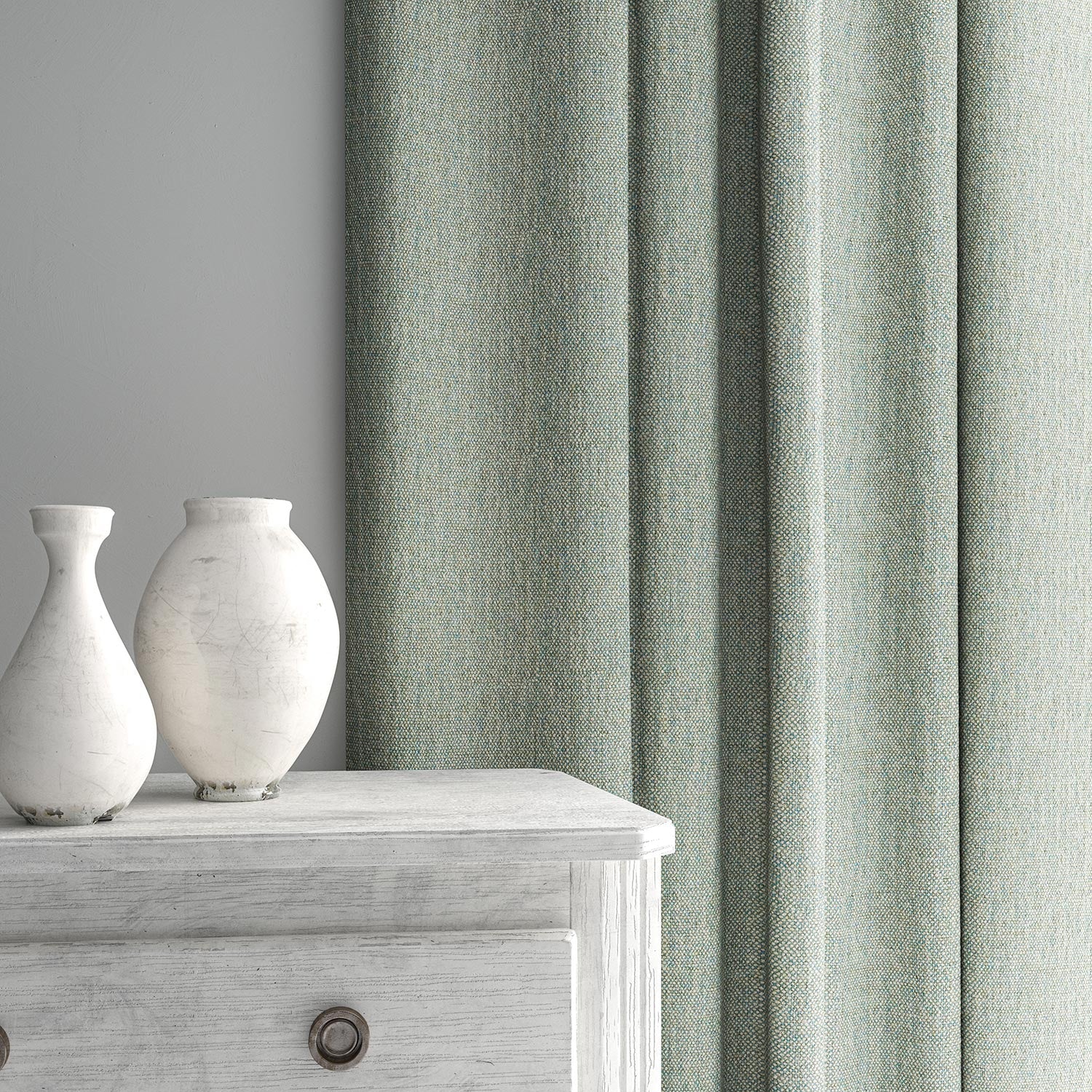 Curtain made from a plain luxurious woven fabric in blue and cream.