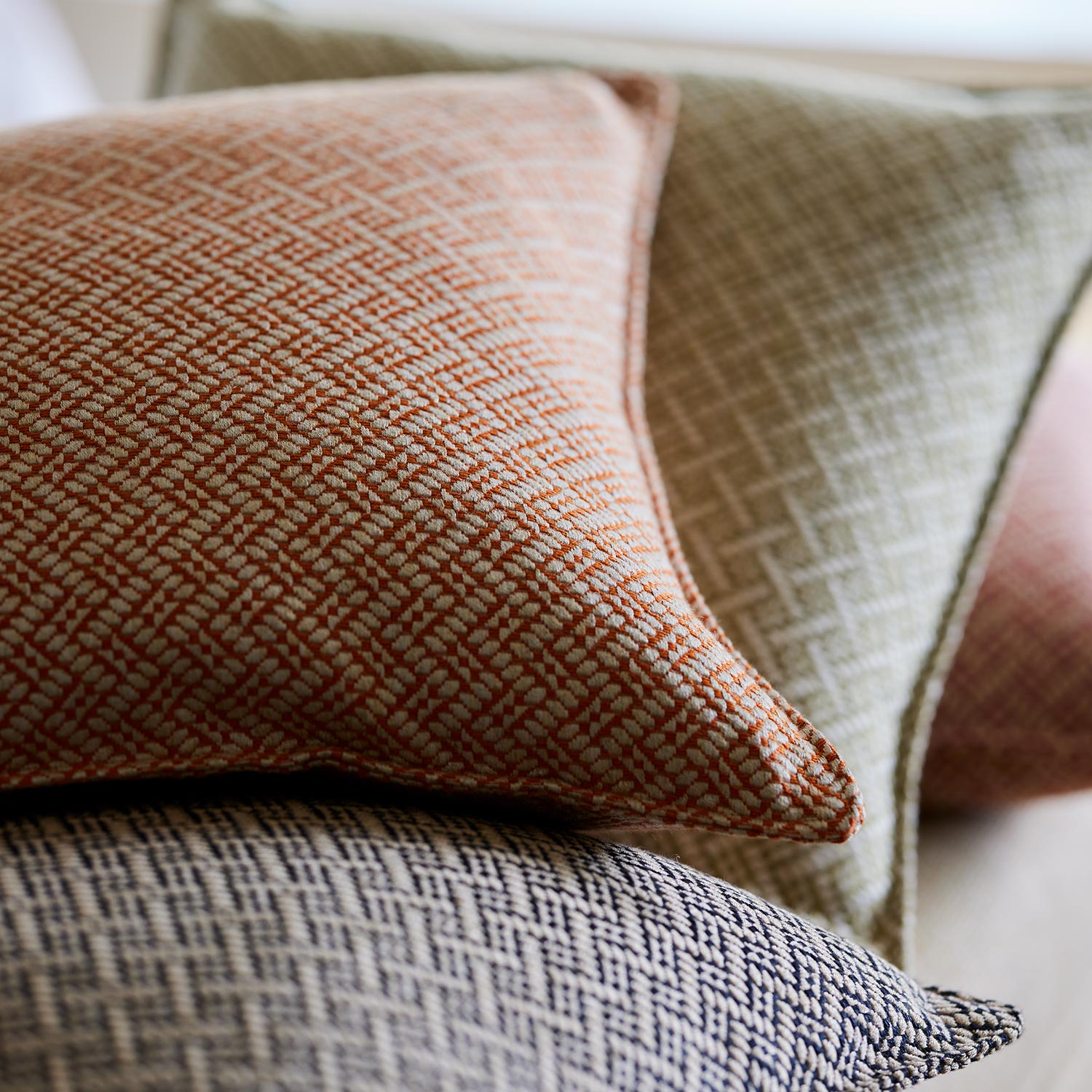 Cushions in red and off-white woven fabric featuring a trellis pattern.