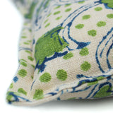 A green, blue and cream linen cushion with a stylised floral pattern.