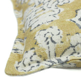 A yellow, blue and cream linen cushion with a block print pattern.
