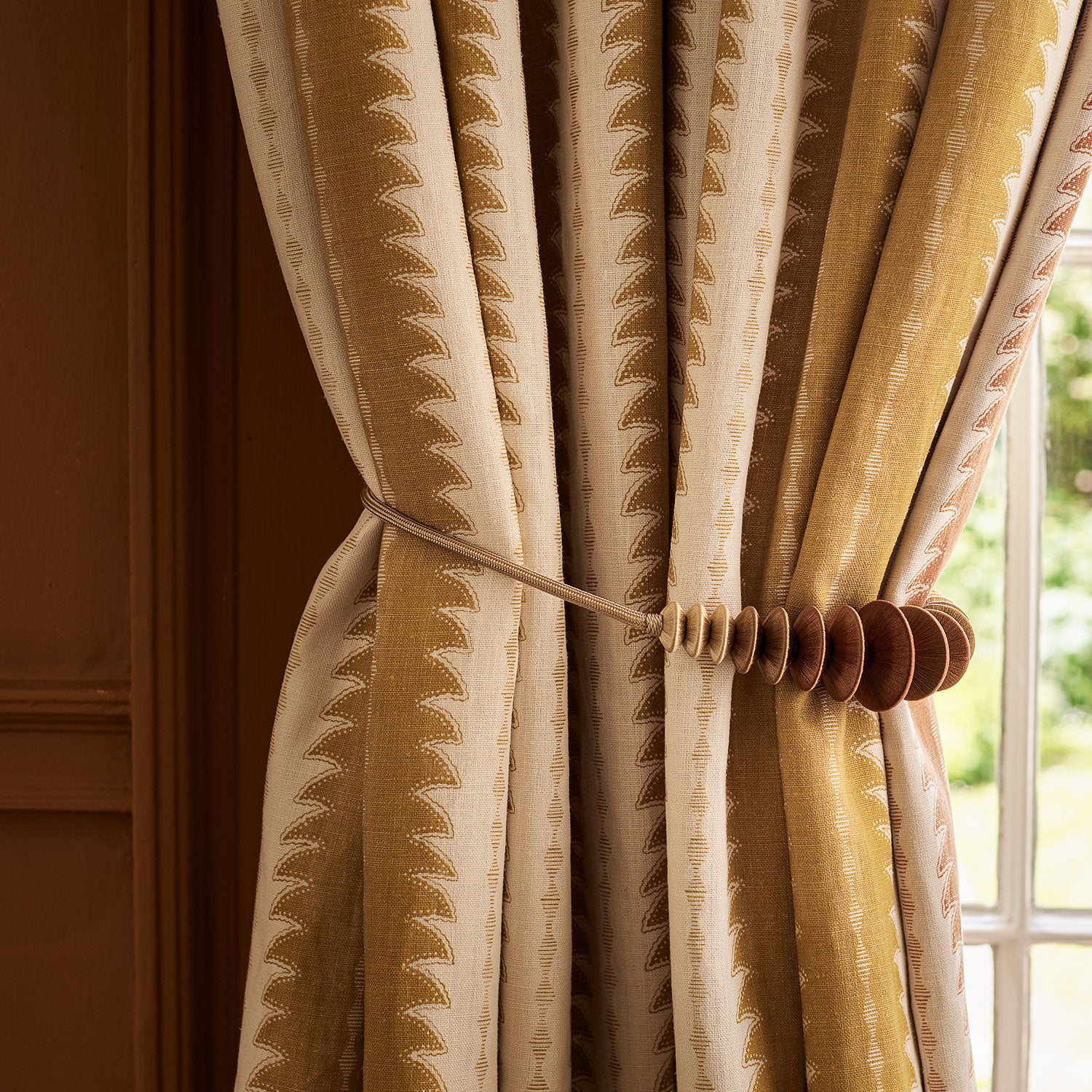 Curtains made from a printed linen fabric in yellow and off white, featuring a striped fern design.