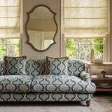 Sofa upholstered in a printed linen fabric in blue and off white featuring a mirrored ribbon pattern.