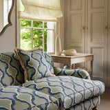 Sofa upholstered in a printed linen fabric in blue and off white featuring a mirrored ribbon pattern.