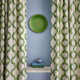 Curtains made from a printed linen fabric in blue, green, and off white featuring a mirrored ribbon pattern.