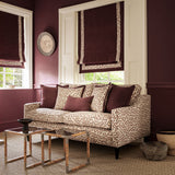 Sofa upholstered in a printed linen fabric in brown, orange, and off white featuring a feel of a classic animal print.