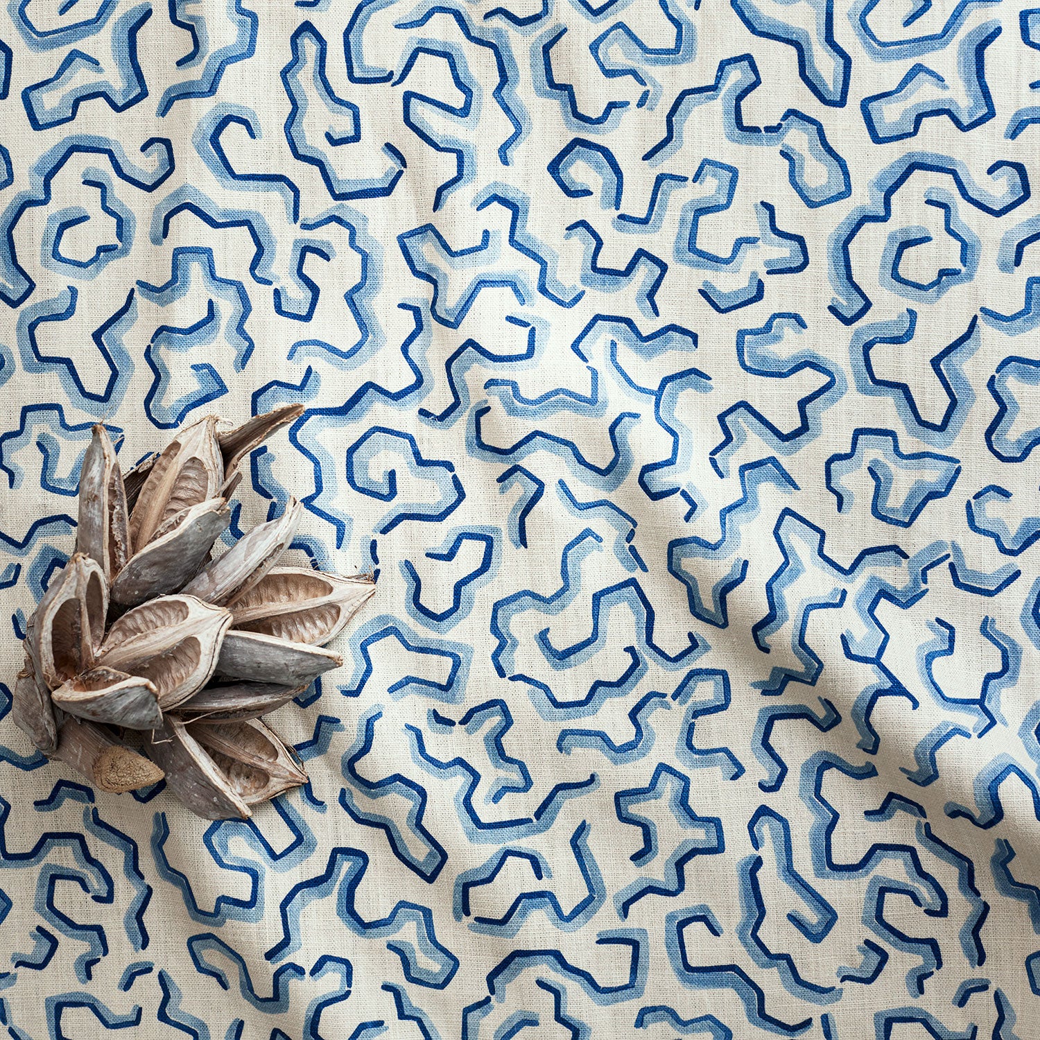 A printed linen fabric sample in blue and off white featuring a feel of a classic animal print.