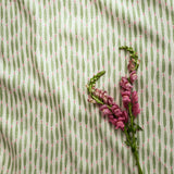 A printed linen fabric sample in green, pink, and off white featuring a Japanese print.
