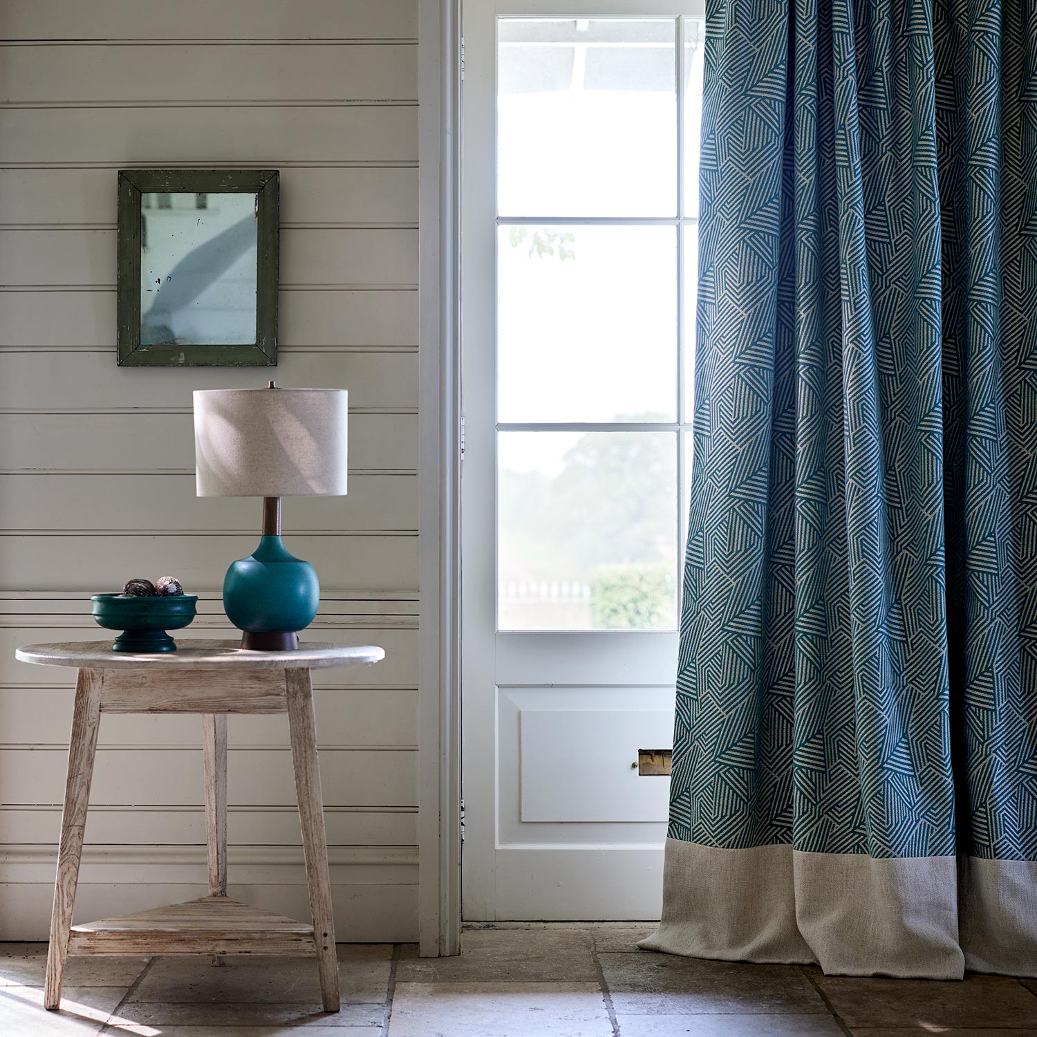 Curtain in a blue and off-white woven fabric featuring a geometric pattern.