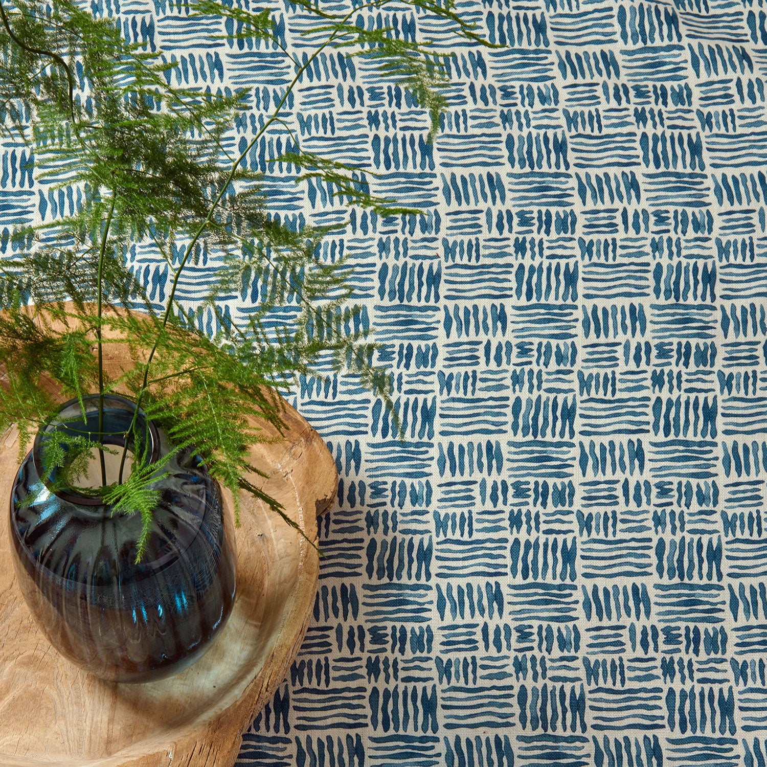 A printed linen fabric sample in blue and off white featuring a basketweave pattern.