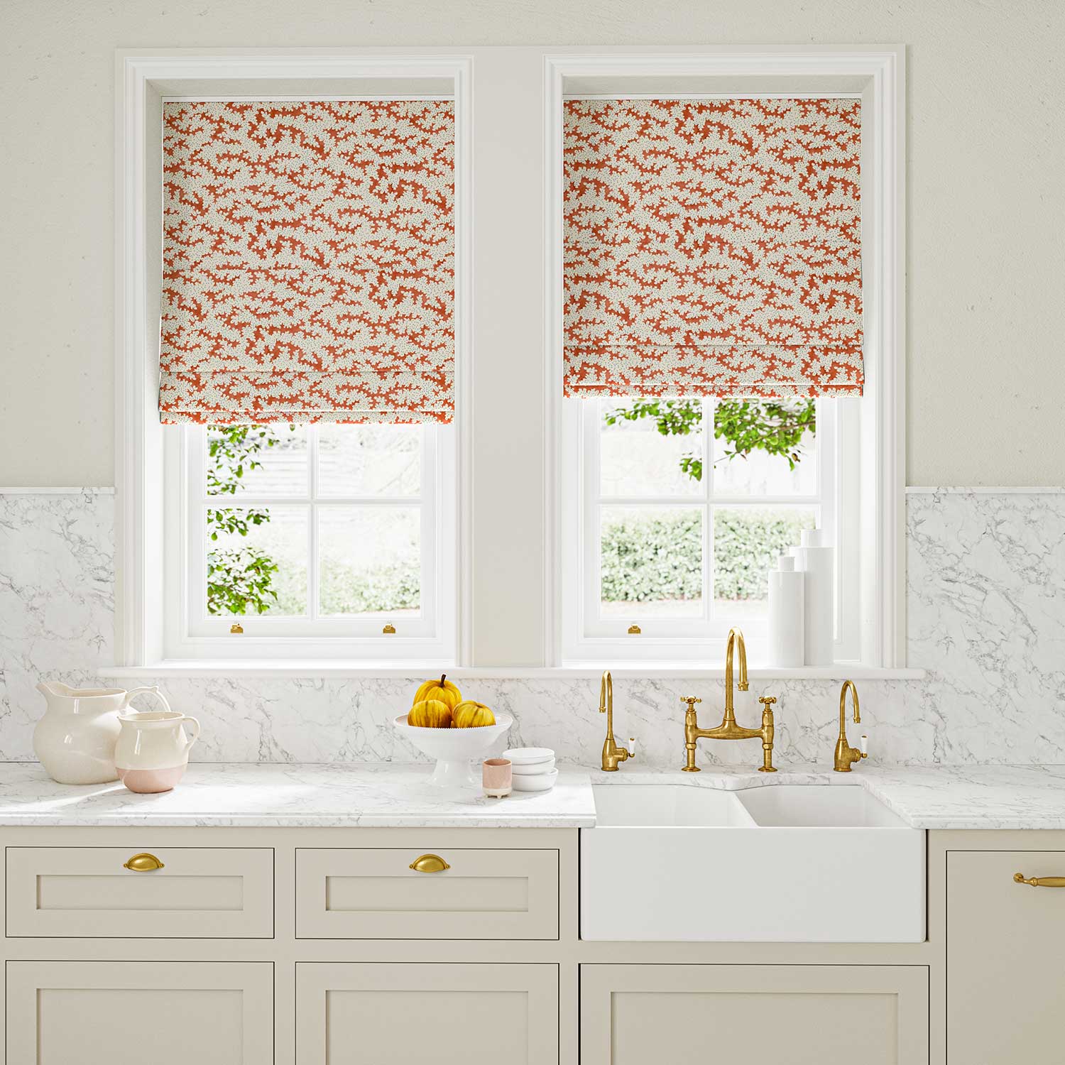 Blinds made from a printed linen fabric sample in orange, blue and off white featuring a stylized coral pattern.