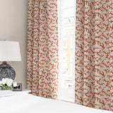 Curtains made from a printed linen fabric sample in orange, blue and off white featuring a stylized coral pattern.