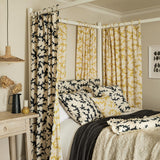 Curtains made from a printed linen fabric sample in yellow, blue and off white featuring a stylized coral pattern.