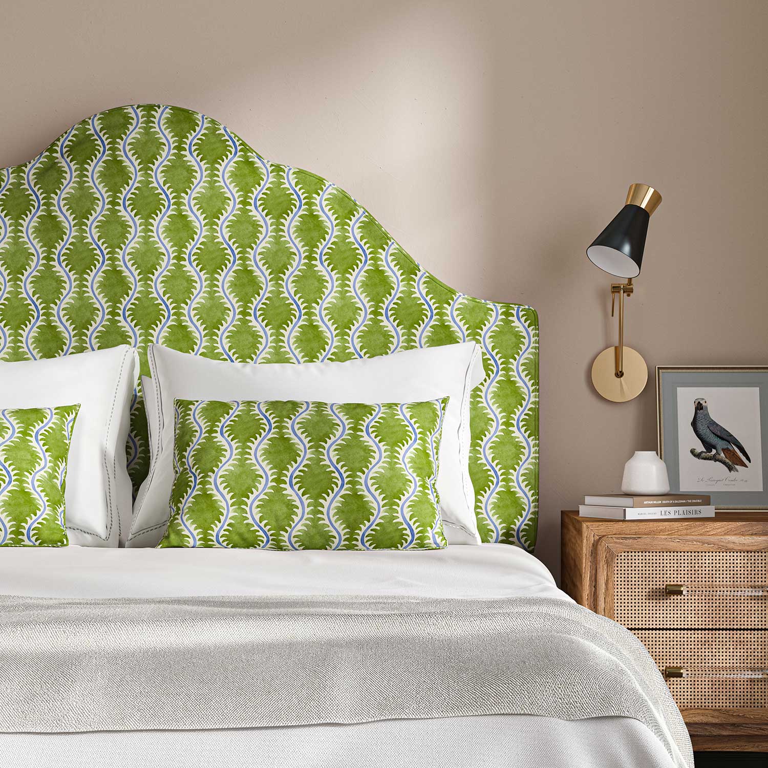 Headboard upholstered in a printed linen fabric sample in blue and green featuring a stylized fern pattern.
