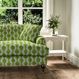 Sofa upholstered in a printed linen fabric sample in blue and green featuring a stylized fern pattern.